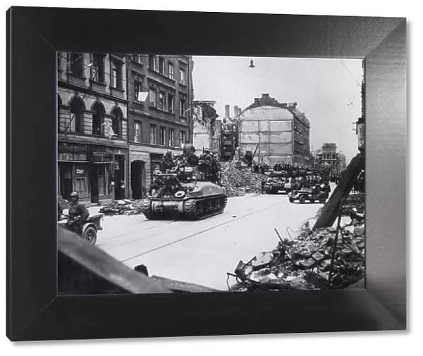 Allied tanks laden with infantry move into a heavily bombed Munich on April 29, 1945