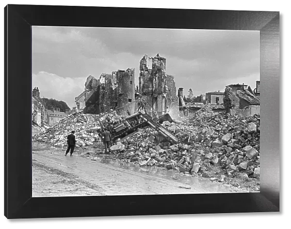 Ruined buildings and wrecked German transport in the streets of Montebourg as a result of