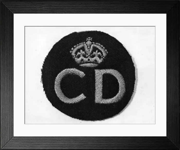 Framed Print : Civil Defence service badge, woven in a gold colour, worn on the left breast of a uniform Framed Print : Civil Defence service badge, woven in a gold colour, worn on the left breast of a uniform