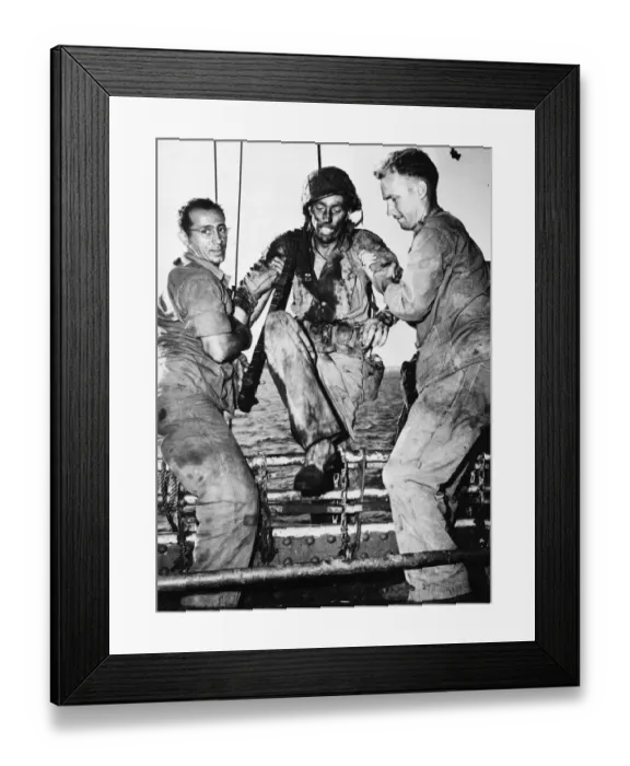 Framed Print : A US marine is assisted onboard a American transport by two Coast Guardsmen after