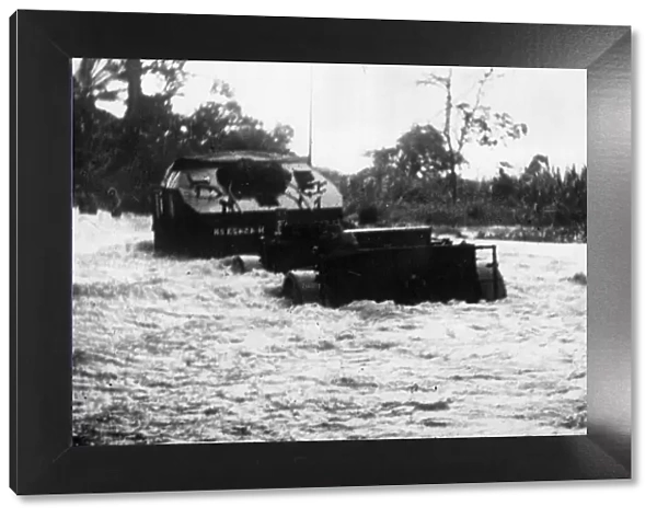 A convoy of British 25 pounders navigate a flooded section of road on their way up