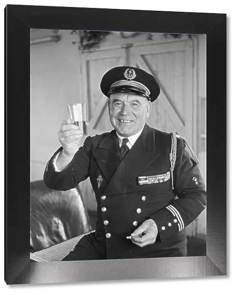 Un-named Free French Naval Captain poses with a drink for the press at their barracks in