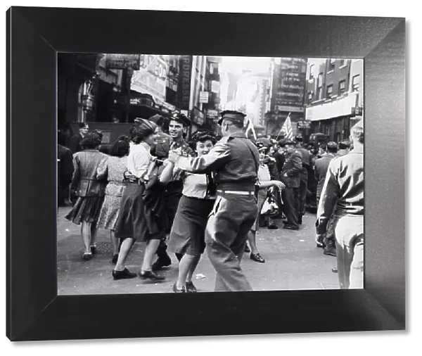 Servicemen and women dancing in the streets of London on VJ Day after Japan surrendered