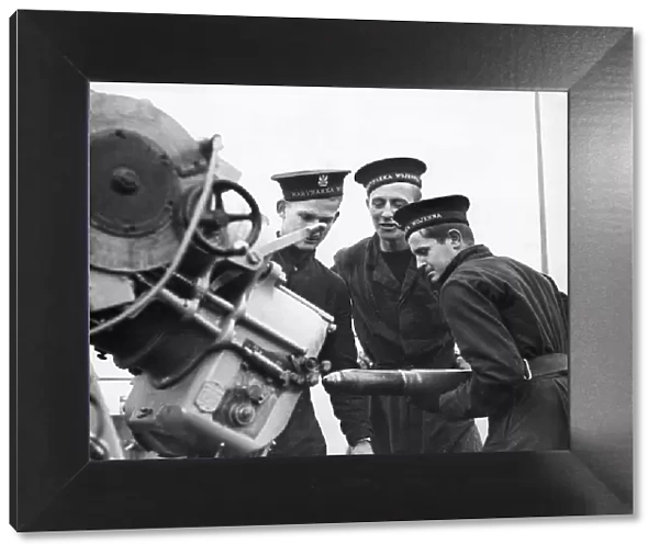 Three sailors manning a 3 inch anti-aircraft gun at gun practice on board the Polish Navy