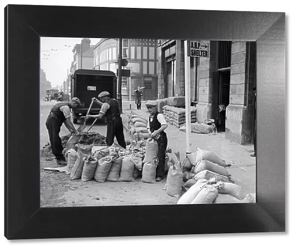 Corporation workmen filling and place sandbags to protect civic building from bomb blast