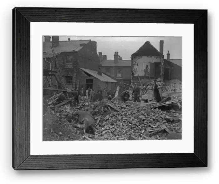 Framed Print : A. R. P workers clearing the debris from a wrecked Smethwick Stables where four horses Framed Print : A. R. P workers clearing the debris from a wrecked Smethwick Stables where four horses