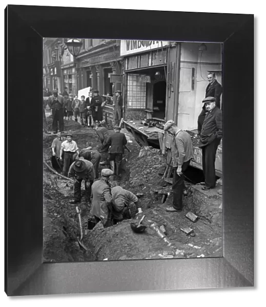 Workmen inspect a crater in central Birmingham following a raid on the city