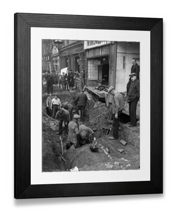 Framed Print : Workmen inspect a crater in central Birmingham following a raid on the city Framed Print : Workmen inspect a crater in central Birmingham following a raid on the city