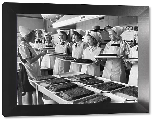 Schoolgirls serve meals to children during the Second World War. 28th October 1941