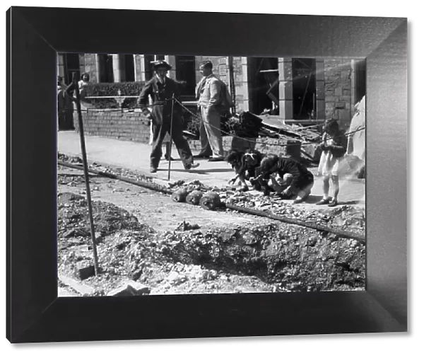 Children search for bomb shrapnel in the gutters of Edward Street, Redfield