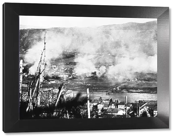 Smoke rises from a German town under assault by of the 10th Armoured Division