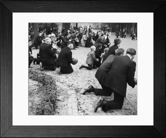 Framed Print : A scene in Leende as the villagers kneel and pray, for the four victims killed by Framed Print : A scene in Leende as the villagers kneel and pray, for the four victims killed by