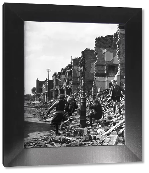 Picture shows young boys playing in the ruins of housing decimated in the Blitz of