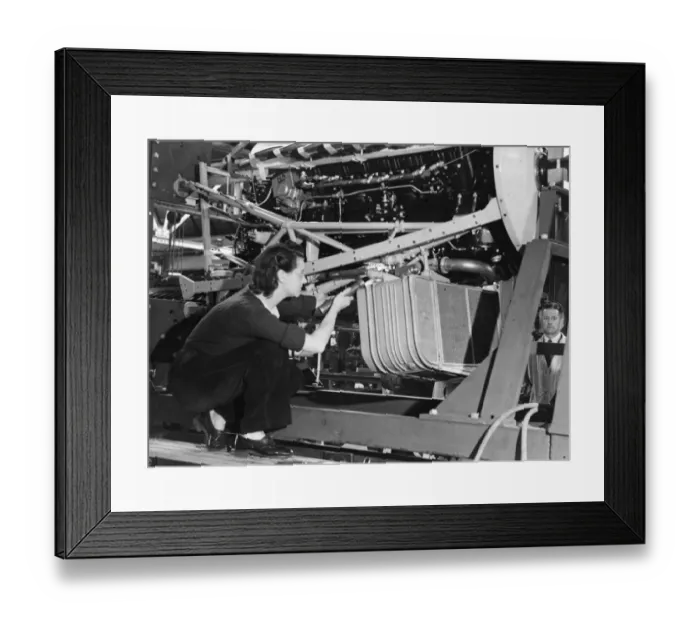 Framed Print : A female worker inspecting the cooling system of a Lancaster bomber plane of the Royal