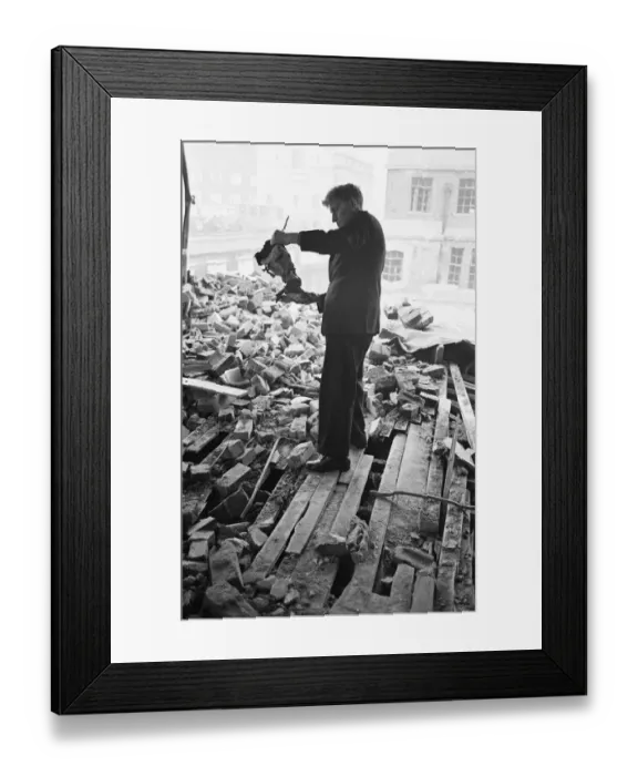 Framed Print : A member of staff holds a damaged instrument amongst the rubble of The Westminster Framed Print : A member of staff holds a damaged instrument amongst the rubble of The Westminster