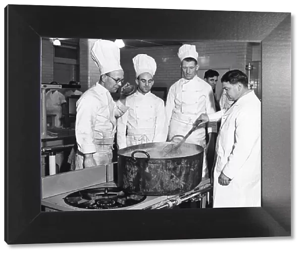 Kitchen workers in the West of England Aeroplane Works. Chefs around a large tub
