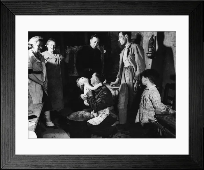 Framed Print : Sergeant Ted Okey helps a French woman bathe her child whilst Tommy Dalby talks to Framed Print : Sergeant Ted Okey helps a French woman bathe her child whilst Tommy Dalby talks to