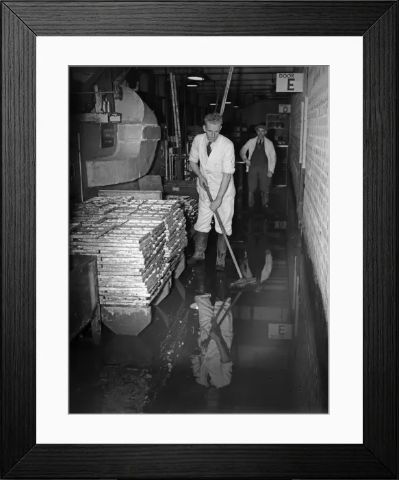 Framed Print : Staff at the Cadbury factory at Bournville clean up after flooding caused by a direct hit