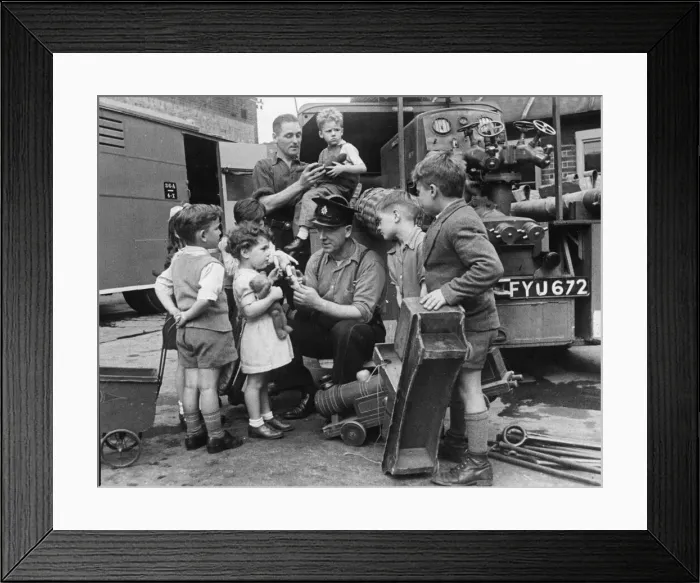 Framed Print : Children from Stoke Newington bring their broken toys to Leading Fireman Herbert Rogers Framed Print : Children from Stoke Newington bring their broken toys to Leading Fireman Herbert Rogers