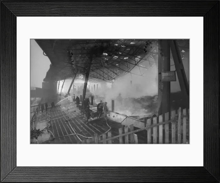 Framed Print : Firemen dampen down the burnt-out shell of the grandstand at St Framed Print : Firemen dampen down the burnt-out shell of the grandstand at St