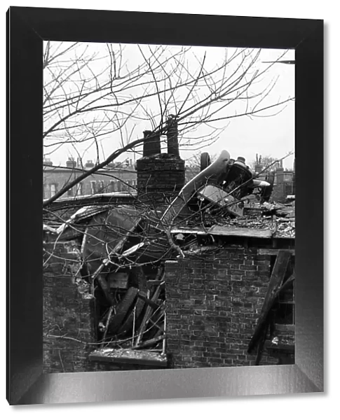 A London Fire Service auxiliary van thrown on to a roof by a falling bomb during