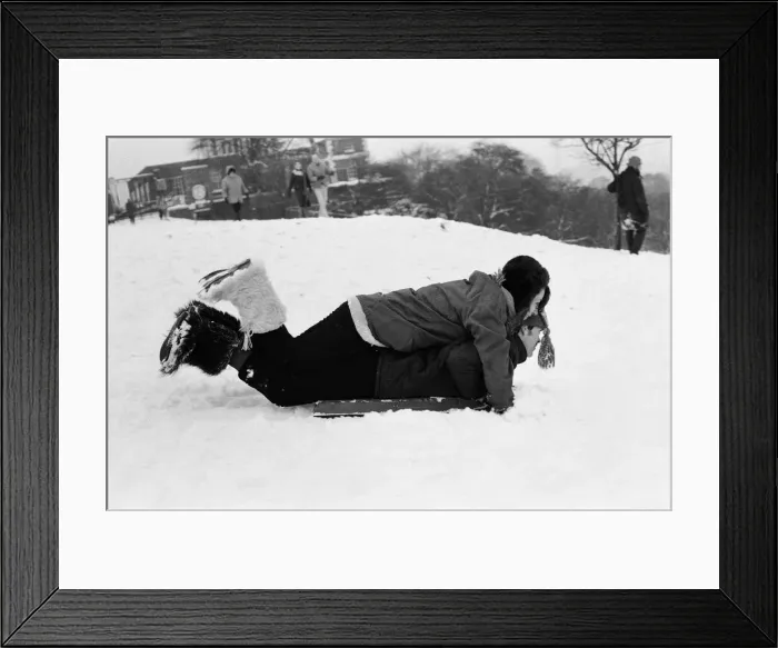 Framed Print : A couple sledging in Greenwich Park, London, 27th December 1970 Framed Print : A couple sledging in Greenwich Park, London, 27th December 1970