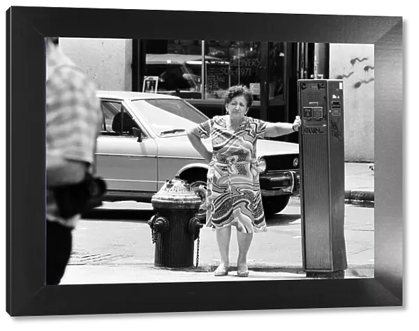 Woman leans against Street Fire Alarm Box, used to report an emergency, New York, USA