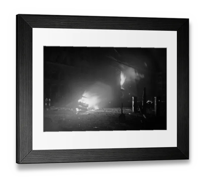 Framed Print : The wreckage of a car a blaze after being hit by a bomb