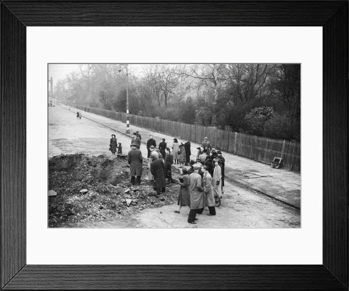 Framed Print : Members of the public inspect a crater in Albert Bridge Road, Battersea, London
