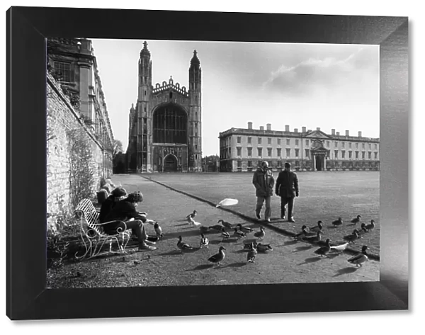 People talking a walk on the lawn outside Kings College in central Cambridge