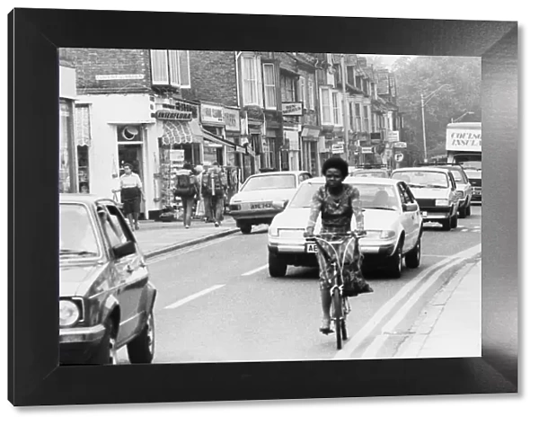 A cyclist goes down Mill Road, Cambridge, Cambridgeshire