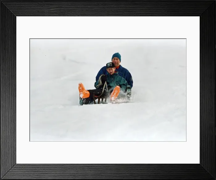 Framed Print : Prince Charles on a sledge with Prince Harry while on holiday in Klosters, Switzerland