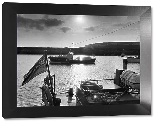 The sea is pool-placid as the sun goes down and the Barry lifeboat stands at her harbour