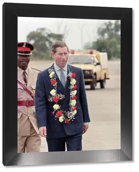 Charles, Prince of Wales, arrives in Swaziland, wearing a flower garland of carnations