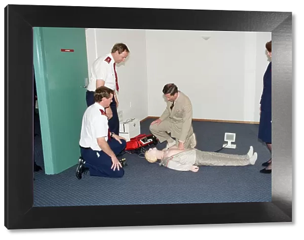 Prince Charles demonstrating resuscitation techniques on an inflatable doll at an