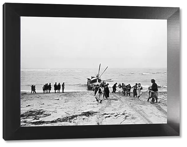 Women pull the lifeboat ashore at Cresswell lifeboat station in Northumberland