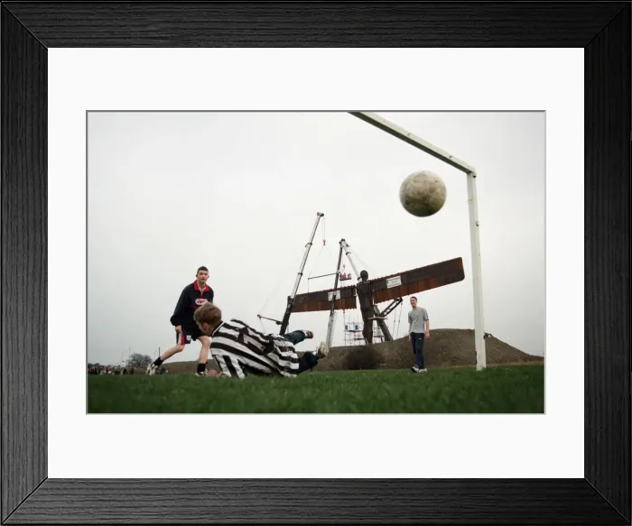 Framed Print : A football game takes place in front of the Angel of the North, Gateshead