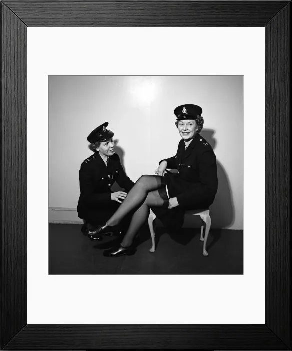 Framed Print : Policewomen Hilda Whitcombe (left) and Betty O Brien trying on the new issue for Framed Print : Policewomen Hilda Whitcombe (left) and Betty O Brien trying on the new issue for