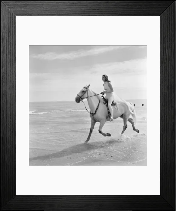 Framed Print : Diana Rigg, who plays Emma Peel, pictured riding a white horse across the beach at St Framed Print : Diana Rigg, who plays Emma Peel, pictured riding a white horse across the beach at St