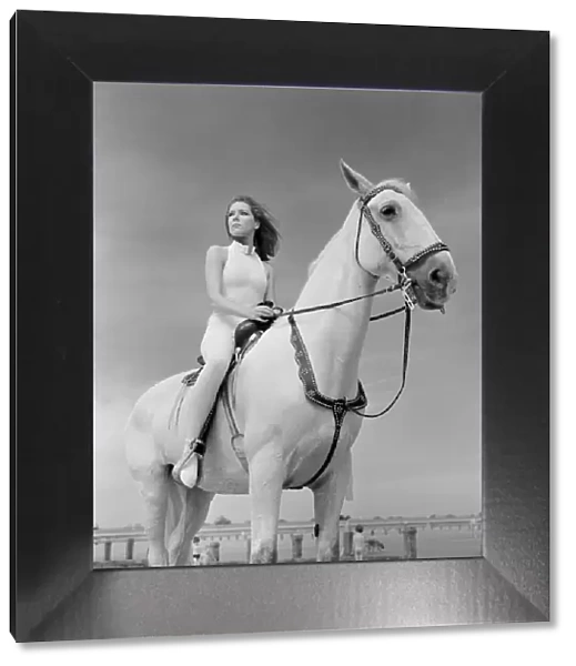 Diana Rigg, who plays Emma Peel, sitting on a white horse on the beach at St Mary