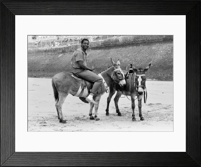 Framed Print : Lenny Henry riding a Donkey at Blackpool Beach, Lancashire. 15th July 1984 Framed Print : Lenny Henry riding a Donkey at Blackpool Beach, Lancashire. 15th July 1984
