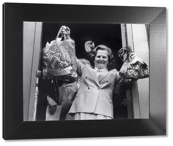 MARGARET THATCHER HOLDS ALOFT BAGS WITH SHOPPING BOUGHT IN 1974 AND 1979 TO ILLUSTRATE