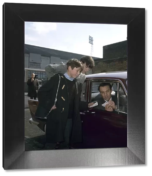 Jimmy Greaves of Tottenham Hotspur signs autographs for young fans as he leaves White
