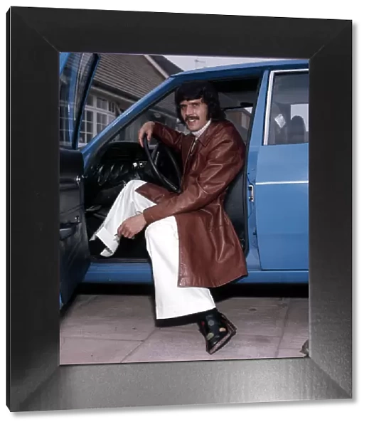 Liverpool footballer Peter Cormack in his car, wearing some of the clothes he has