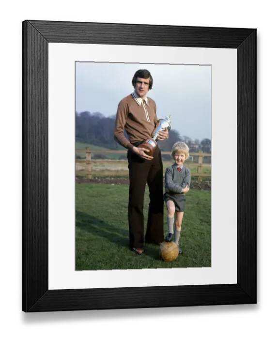 Framed Print : Leeds United footballer Norman Hunter with his five year old son Michael holding Framed Print : Leeds United footballer Norman Hunter with his five year old son Michael holding