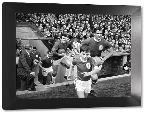 The Liverpool team run onto the pitch with their young mascot before the English league