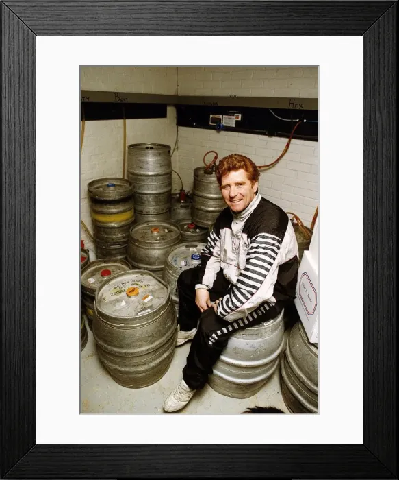 Framed Print : Football player and manager Alan Ball sitting on a barrell in the cellar of his new pub