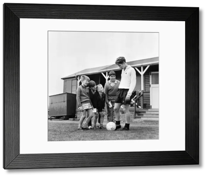 Framed Print : Blackpool and England footballer Alan Ball at the training ground with young autograph