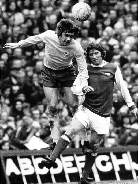 David Nish of Derby County heads the ball from Alan Ball of Arsenal during their league
