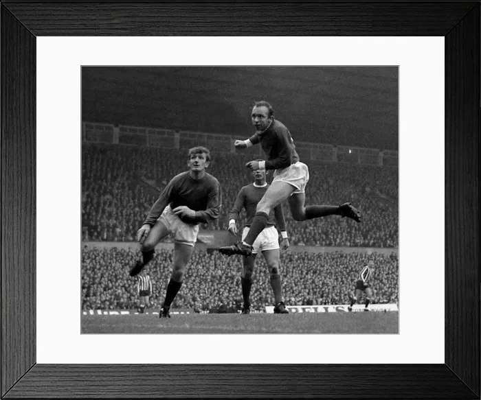 Framed Print : Manchester Uniteds goalkeeper Alex Stepney looks on anxiously as defender Nobby Framed Print : Manchester Uniteds goalkeeper Alex Stepney looks on anxiously as defender Nobby
